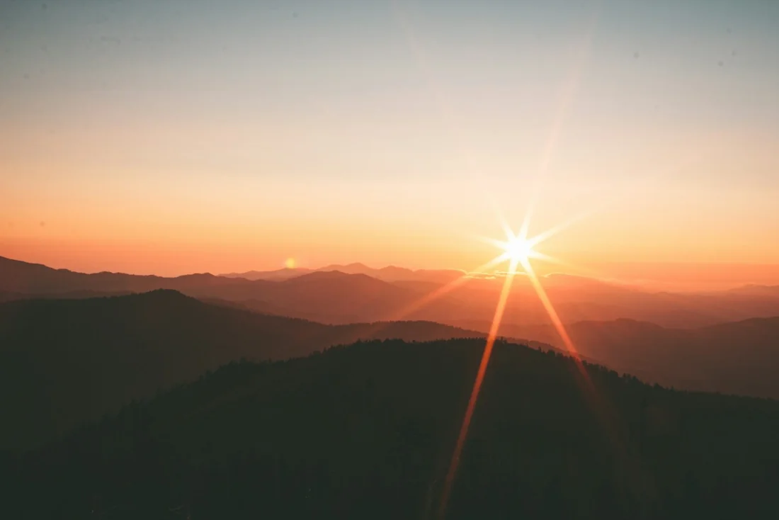 Sun rising above distant hills